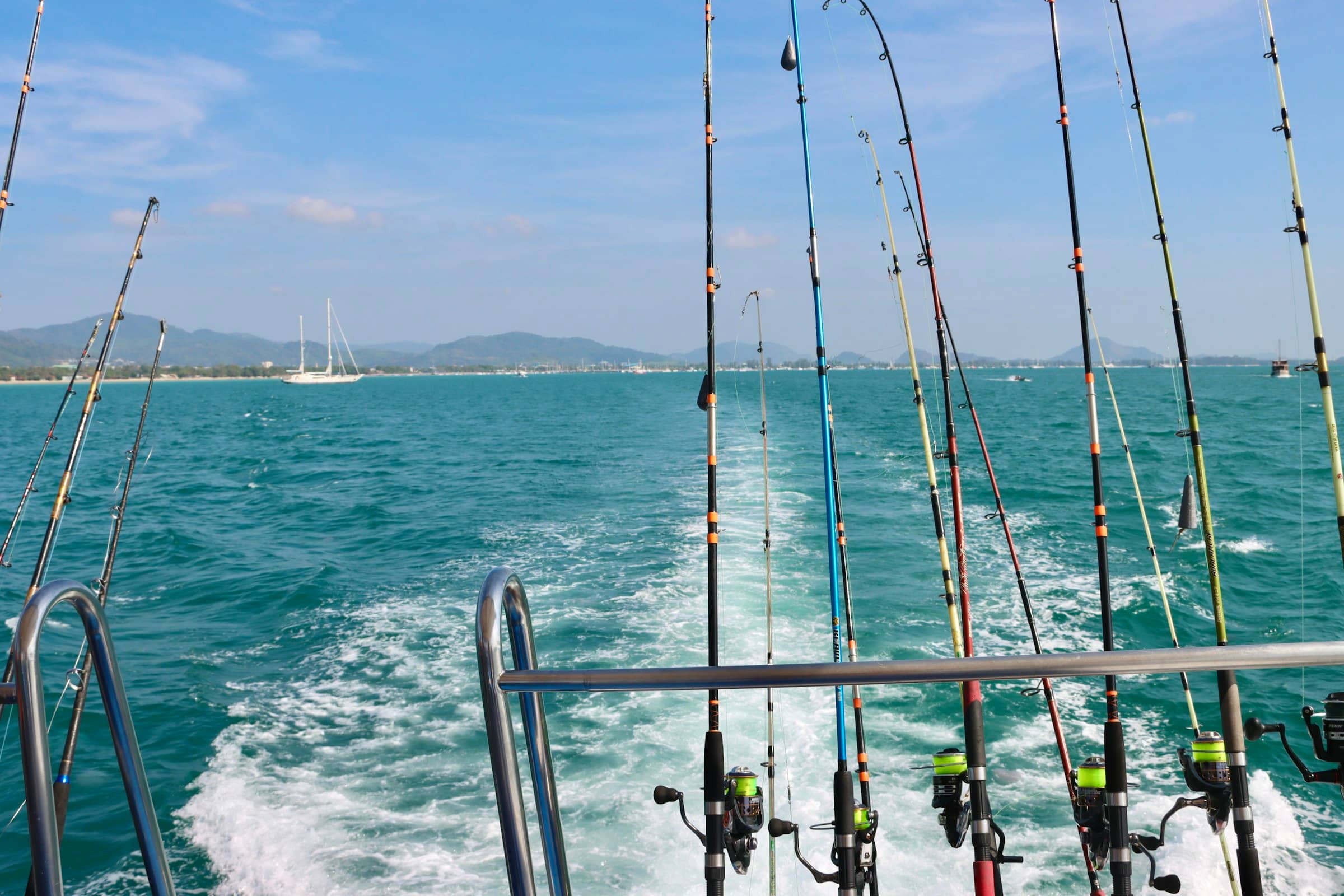 Fishing rods set in holders at a boat stern over open water