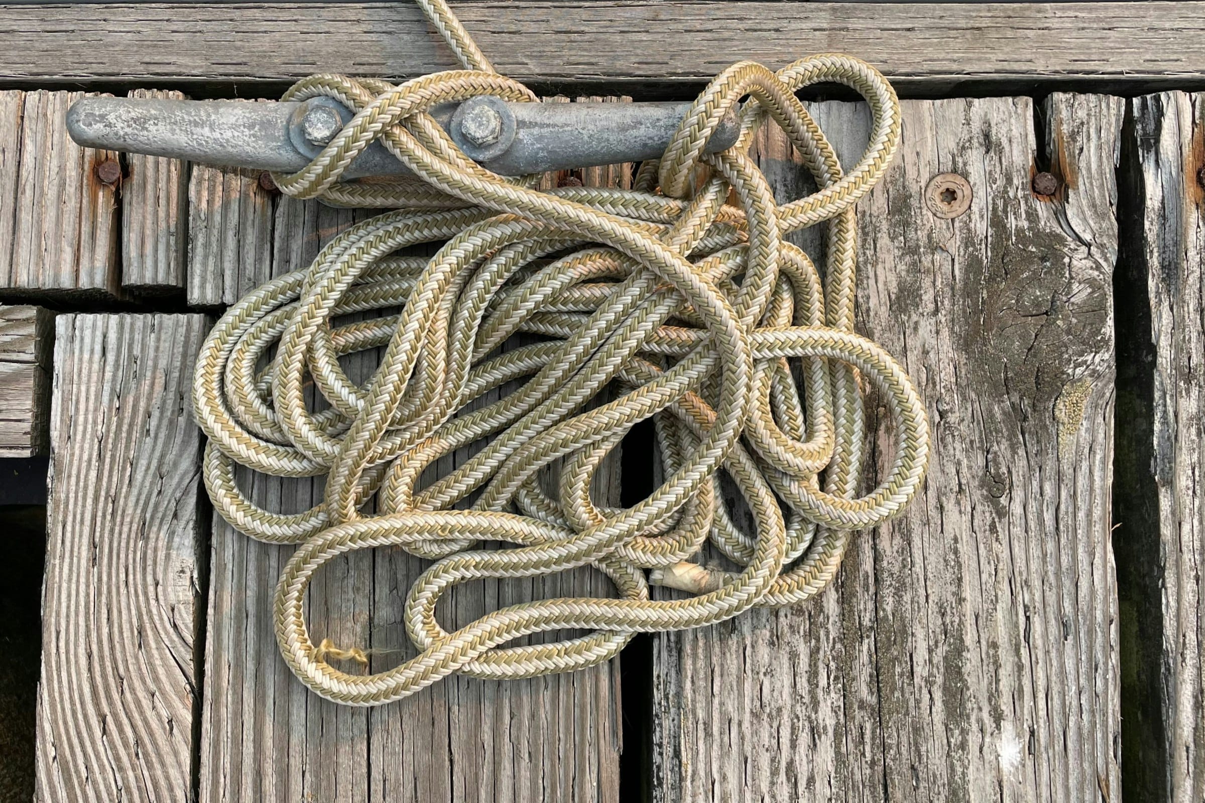 A dock cleat with coiled rope in low morning light